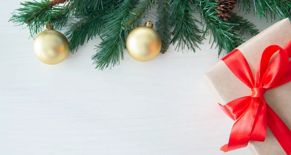 Hafif bir arka planda noel toplarıyla süslenmiş ladin dalı, noel kartı