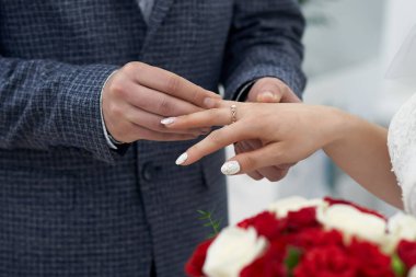 Damat nazikçe ve sevgiyle gelinin parmağına güzel bir yüzük takar.