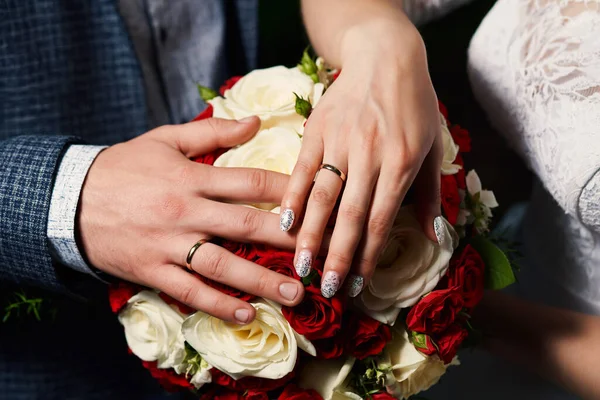 Närbild Bruden Och Brudgummen Lägga Händerna Buketten Och Visa Bröllopsringarna — Stockfoto