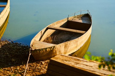 Gün batımında kıyıda yalnız eski bir tekne