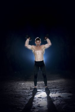 Güçlü genç erkek bir mağarada halter kaldırma