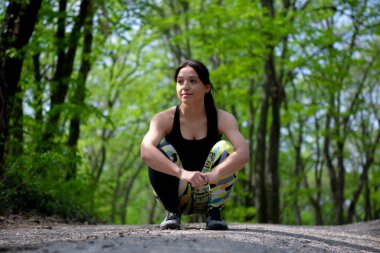 Formda ve genç bir kız NCov küresel salgını sırasında sağlığını korumak için açık havada egzersiz yapıyor.