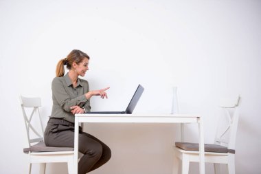Genç bir iş kadını laptopuyla evden çalışıyor.