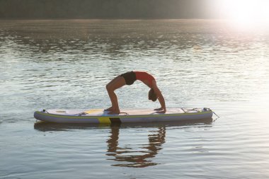 Gün doğarken meditasyon yapan ve yoga yapan bir kadın.
