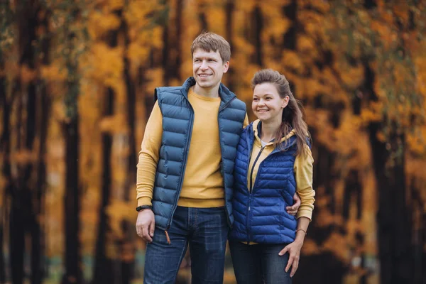 Retrato de una pareja feliz en el parque de otoño, ambos mirando en una dirección — Foto de Stock
