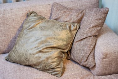 Kanepenin köşesinde, modern malzemeden yapılmış iki güzel yastığın yakın plan fotoğrafı. İç dizayn kavramı..