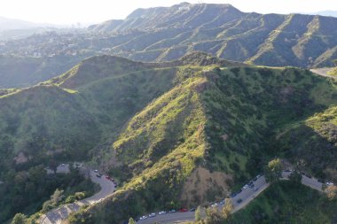 Los Angeles tepelerinin, şehirlerin ve tepeler arasındaki yolların havadan görüntüsü.