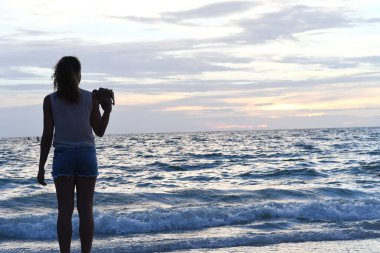 Deniz ve iskelenin arka planında bir kadının siluetinin güzel bir manzarası. 