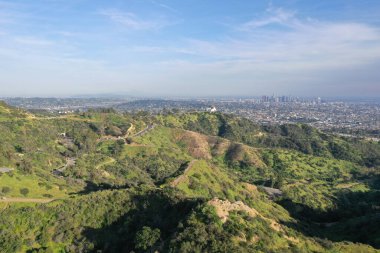 Los Angeles tepelerinin, şehirlerin ve tepeler arasındaki yolların havadan görüntüsü.