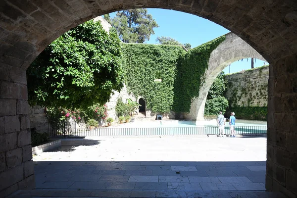 Sarmaşık duvarlı ve kemerli kaledeki yapay gölet manzarası