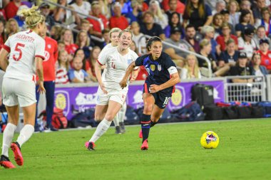 USWNT oyuncusu Carli Lloyd # 10 koşu, 5 Mart 2020 tarihinde Orlando Florida 'daki Exploria Stadyumu' nda düzenlenen 2020 SheBelieves Kupası sırasında İngiliz oyuncuların yanından geçer..  