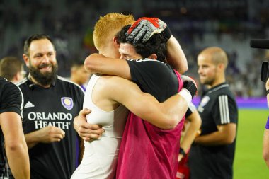 Orlando City's goalies Adam Grinwis (left and Brian Rowe (23) hug to celebrate victory over NYC FC during the U.S. Open Cup at Exploria Stadium in Orlando, Floria on Wednesday July 10, clipart