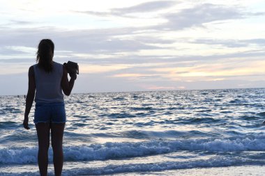 Deniz ve iskelenin arka planında bir kadının siluetinin güzel bir manzarası. 