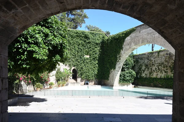 Sarmaşık duvarlı ve kemerli kaledeki yapay gölet manzarası