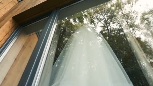Mooie trouwjurk weegt op een hanger. Villa met panoramisch raam. Bruidshuwelijk in Zweden — Stockvideo