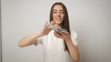 Zengin ve güzel bir iş kadını güzel bir gülüşle 100 dolarlık banknotları saçıyor. Maaş. Mutlu işçi