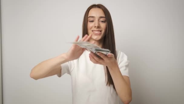 Mujer rica y hermosa de éxito de negocios con una hermosa sonrisa que dispersa billetes de 100 dólares. Salario. Trabajador feliz — Vídeo de stock