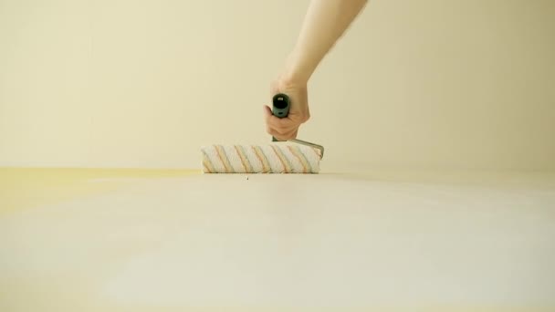 Master paints a wall with a roller in white. Office renovation and renovation. Portrait from the bottom angle — Stock Video