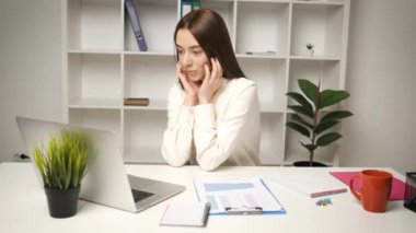 İşyerindeki ofiste çalışan güzel muhasebeci kız laptopa bakan düşünceli bir ifadeyle.