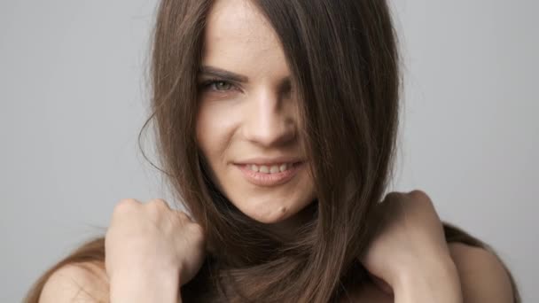 Hermosa chica de aspecto caucásico con el pelo largo negro posando para la cámara en el estudio. Una hermosa mirada en sus ojos — Vídeos de Stock