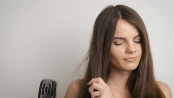 Caucasian woman combing her long brown-black hair in her bathroom and noticing how it falls out — Stock Video