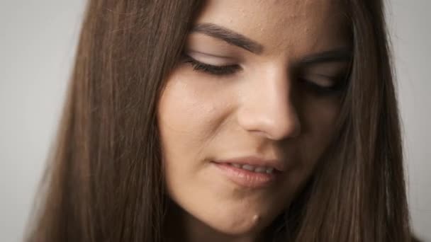 Hermosa chica de aspecto caucásico con el pelo largo negro posando para la cámara en el estudio. Una hermosa mirada en sus ojos — Vídeo de stock