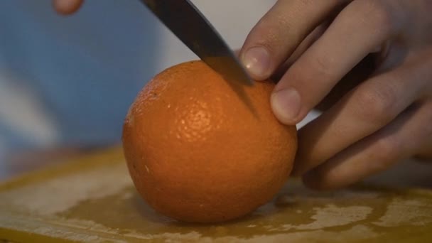 Schneiden einer Orange mit einem Messer — Stockvideo