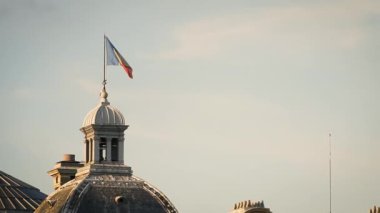 Mavi gökyüzünün arka planında rüzgarlı havada Fransa bayrağı
