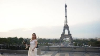Eyfel Kulesi 'nin arka planında dönen beyaz elbiseli mutlu gelin. Mutlu aile