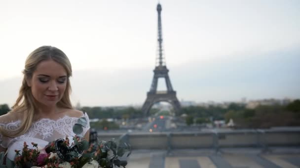 Glad brud i en vit klänning snurrar på bakgrunden av Eiffeltornet. Lycklig familj — Stockvideo