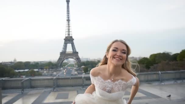 Щаслива наречена у білій сукні, що обертається на задньому плані Ейфелевої вежі. Щаслива родина — стокове відео