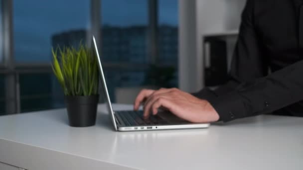 Direttore di ufficio bruna di 30 anni seduto a una scrivania e che lavora su un computer portatile. Ufficio moderno con finestre panoramiche — Video Stock