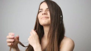 Esmer, banyodaki saçlara krema sürüyor. Kız kendine spa tedavisi uyguluyor.