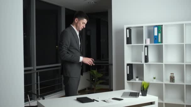 Junger Chef des Unternehmens blieb bis in die Nacht im Büro bei der Arbeit und listet das verdiente Geld auf und geht nach Hause — Stockvideo