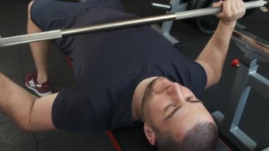 Spor salonunda halter egzersizi yapan profesyonel bir atletin portresi. Sağlıklı bir adam spor salonunda bir egzersiz daha yapar.