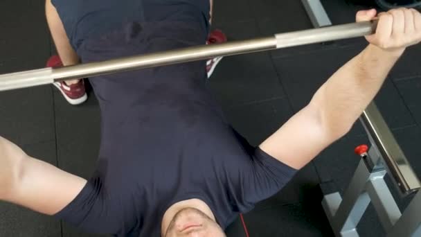 Retrato de un atleta profesional realizando un entrenamiento de barra en el gimnasio. Un hombre sano hace otro ejercicio en el gimnasio — Vídeo de stock