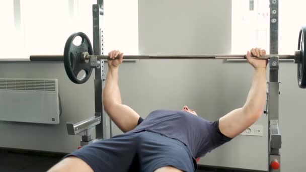 Portret van een professionele atleet die een lange haltertraining in de sportschool uitvoert. Een gezonde man doet nog een oefening in de sportschool. — Stockvideo