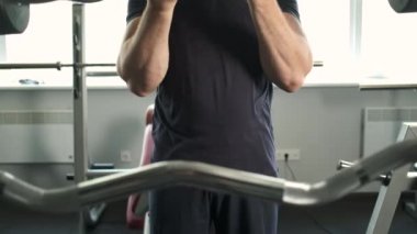 Spor salonunda bisepslerini sallayan pompalı bir sporcunun portresi