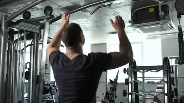 Een actieve gezonde sportman van Kaukasische verschijning komt op een doodskist terecht. gepompte brunette met grote biceps — Stockvideo