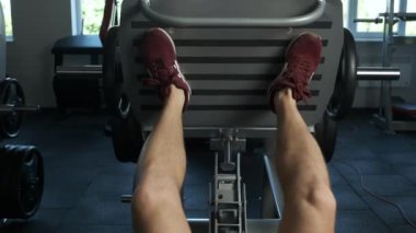 Genç ve hevesli bir atlet yarışmaya hazırlanmak için spor salonunda bir bacak egzersizi daha yapıyor. Sağlıklı Yaşam Tarzı