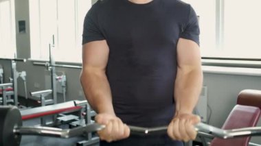 Spor salonunda bisepslerini sallayan pompalı bir sporcunun portresi