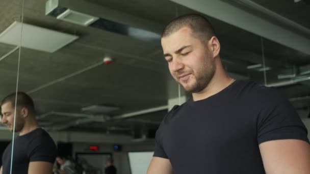 Portret van een atletische man met grote biceps opwarmen op een loopband voor een training in de sportschool — Stockvideo