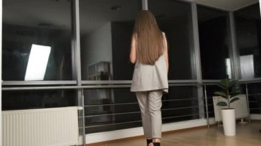 Takım elbiseli beyaz kadın yönetici ofiste sıkı çalıştıktan sonra bir bardak kırmızı şarap içer. Gece şehri. Rahatla.