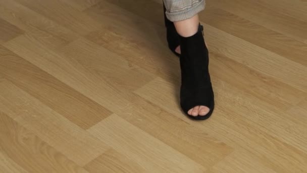 Zwarte vrouw schoenen lopen in het kantoor op het laminaat — Stockvideo