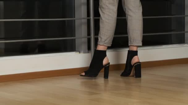 Zapatos de mujer negro caminando en la oficina en el laminado — Vídeo de stock