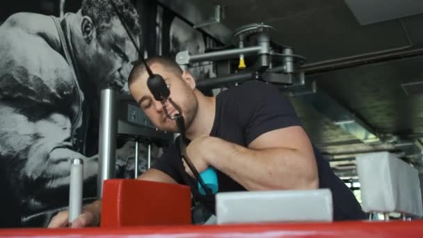 Un atleta sano entrena en una máquina de ejercicio en el gimnasio y se prepara para el amresling. Hombre azul caucásico. Deporte 07.05.2020 — Vídeo de stock