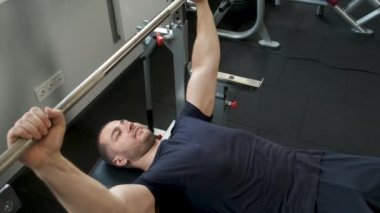 Spor salonunda halter egzersizi yapan profesyonel bir atletin portresi. Sağlıklı bir adam spor salonunda bir egzersiz daha yapar.