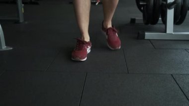 Genç bir sporcu antrenmandan sonra su ve şişe içer.