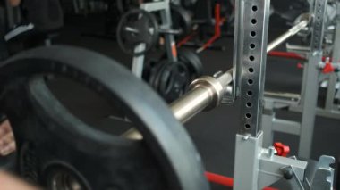 Spor salonundaki sporcu, boynuna 15 kiloluk bir krep koyuyor. Göğse bir egzersiz daha yap.