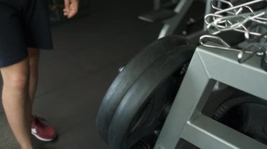 Spor salonundaki sporcu, boynuna 15 kiloluk bir krep koyuyor. Göğse bir egzersiz daha yap.